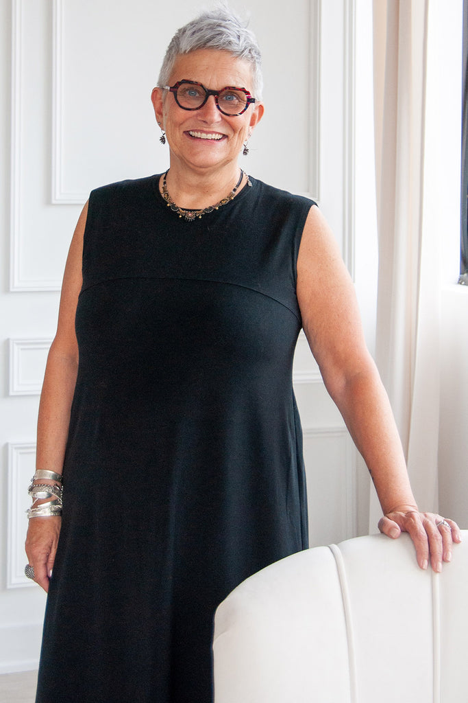 Woman smiling, wearing black tencel tank top Aiken dress by Advika. 