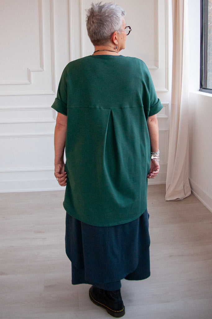 Back view of woman wearing pine green tencel short sleeve slouchy top by Advika. 