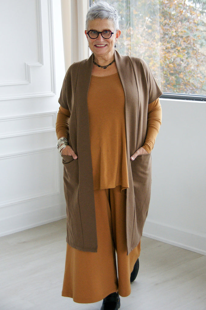 Woman wearing dark brown tencel open front short sleeve duster cardigan with oversized top and wide leg pants by Advika. 